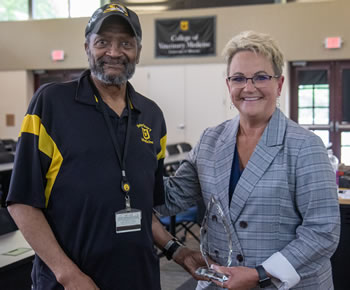 CVM Senior Multimedia Specialist Don Connor accepts the 2023 Dean’s Impact Award from Dean Carolyn Henry.