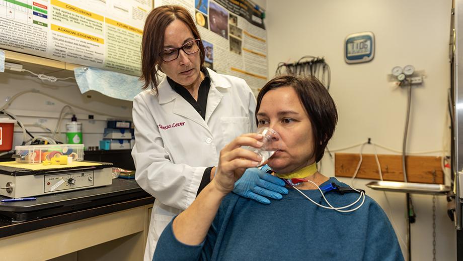 Teresa Lever, left, tests a healthy volunteer's swallowing function in one of her studies. Her innovations are focused on earlier diagnosis of dysphagia and finding effective treatments for human and veterinary patients.