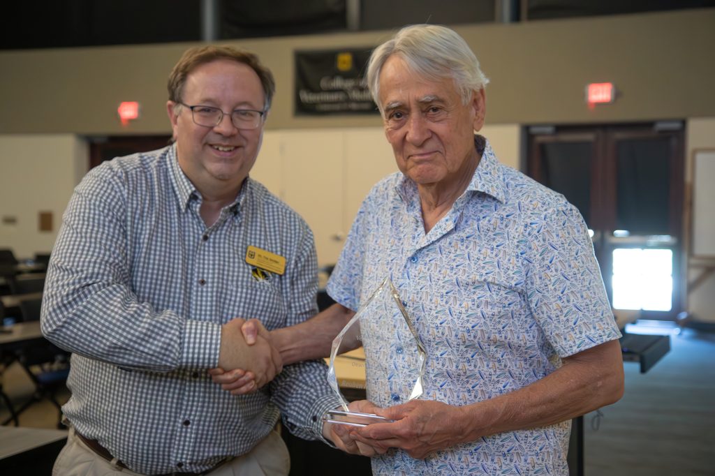 Associate Dean for Academic and Student Affairs Timothy Snider congratulates Reuben Merideth, the recipient of the Dean's Impact Award for Individuals from Outside the College. 