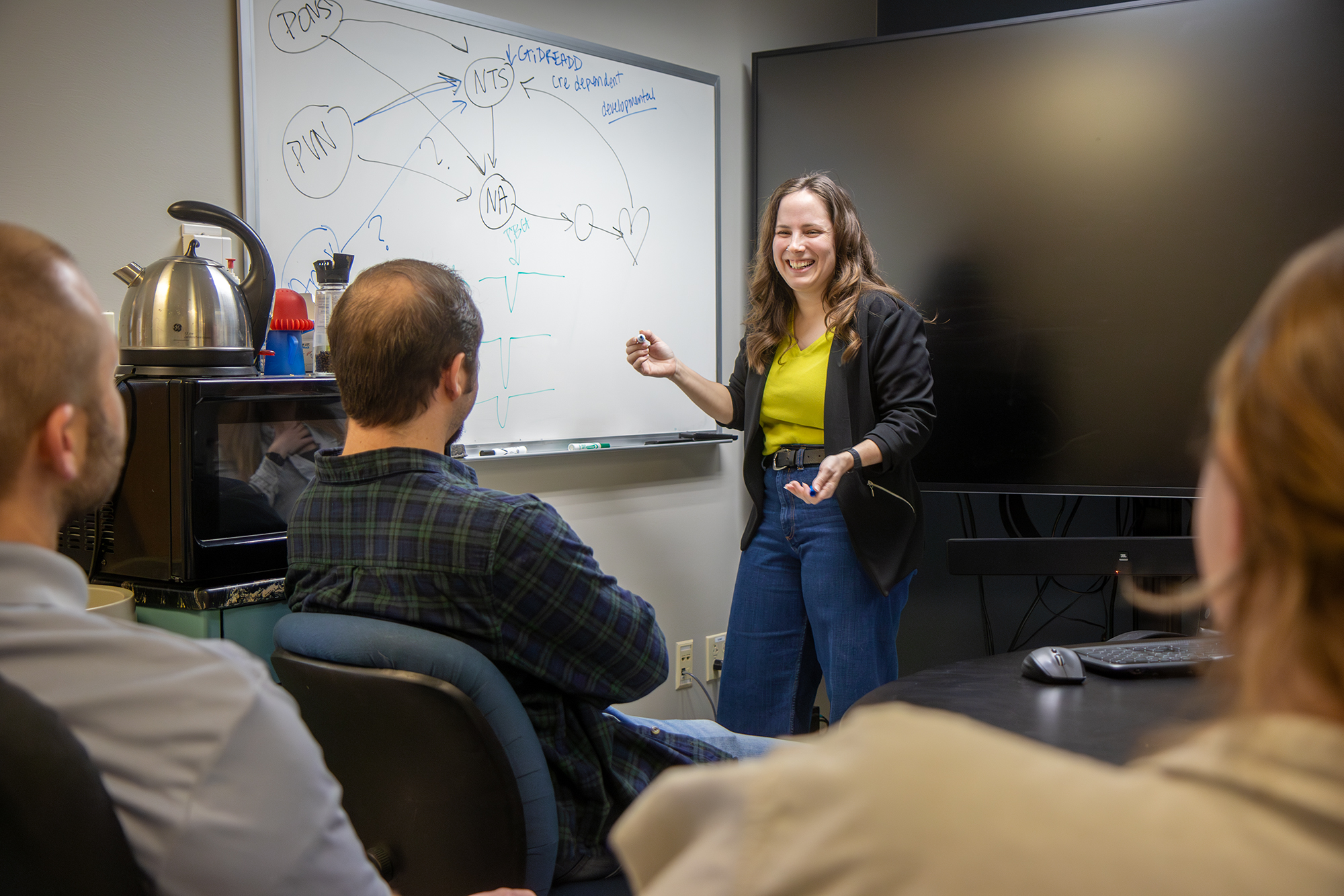 sandy saunders at a white board speaking to a group