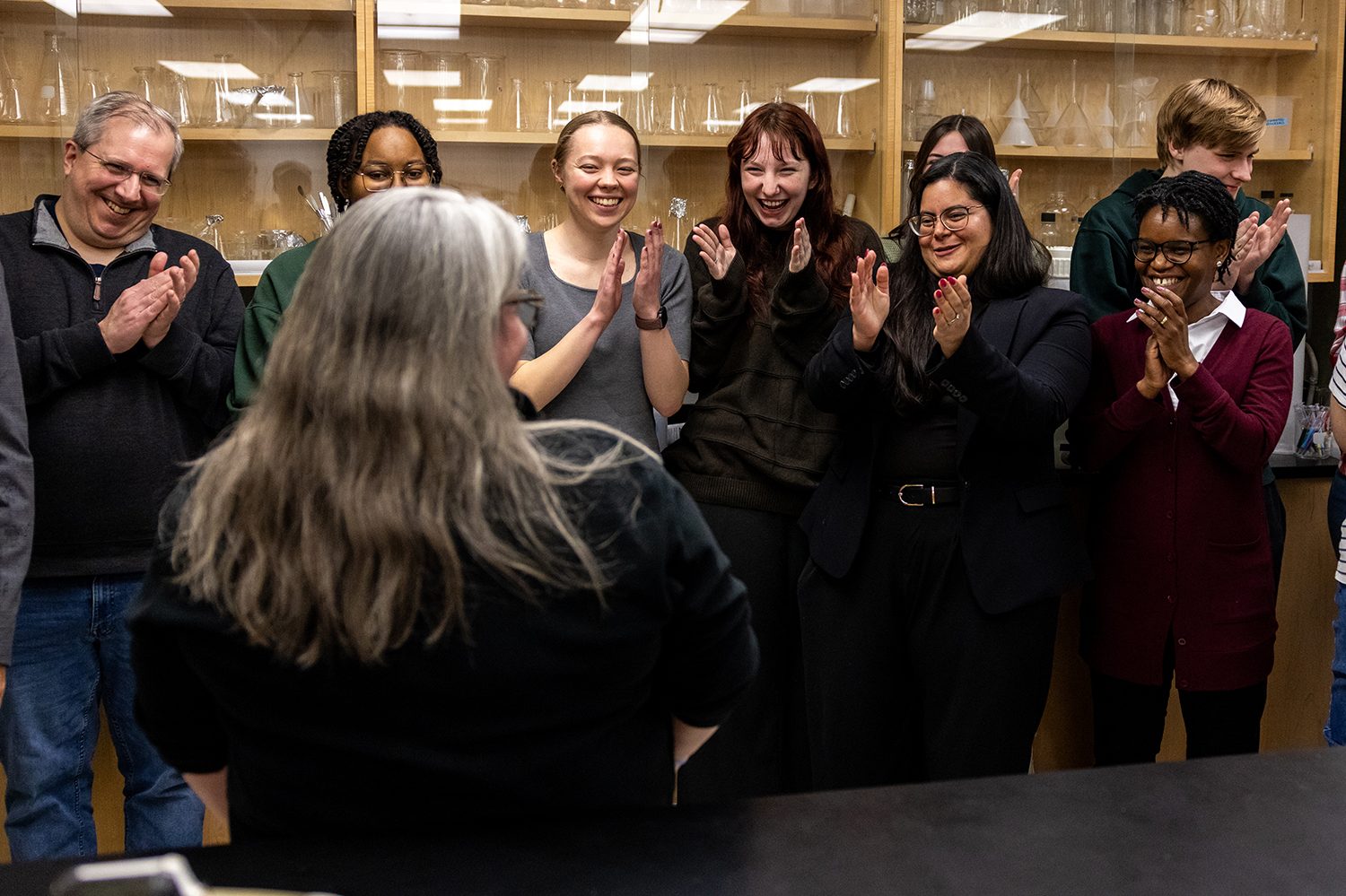 brown's students and peers smile and clap