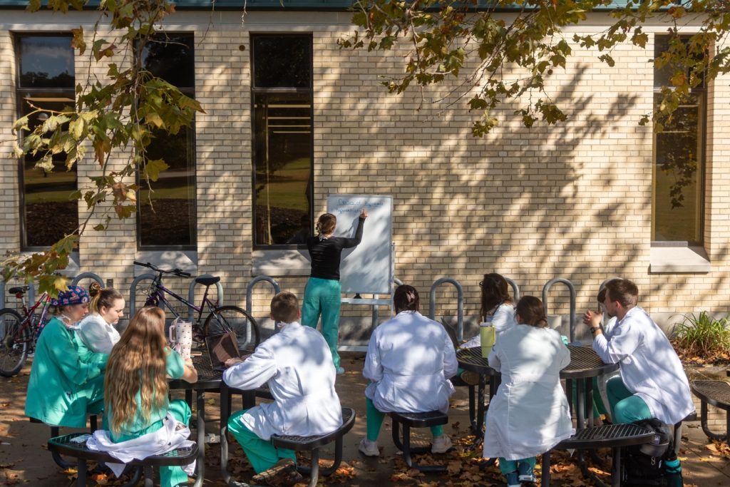 Jess Taylor Brune leading rounds in front of the veterinary medicine building.