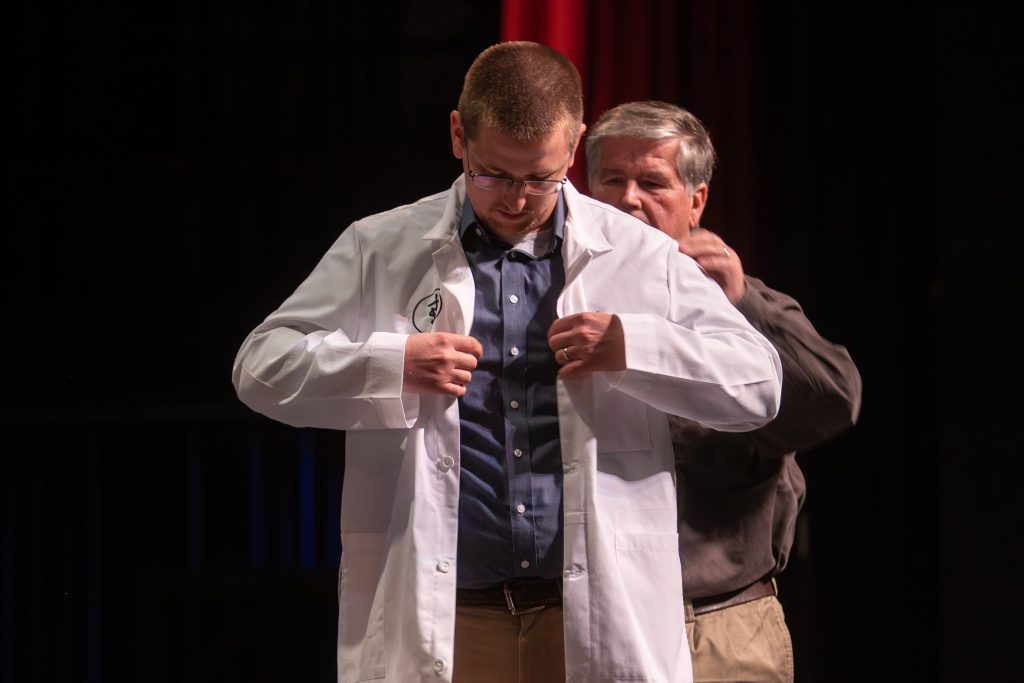 Dan Cook putting on his white coat