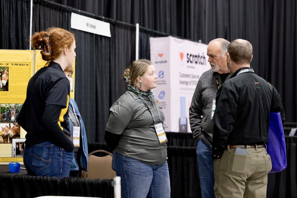 Students speak with attendees