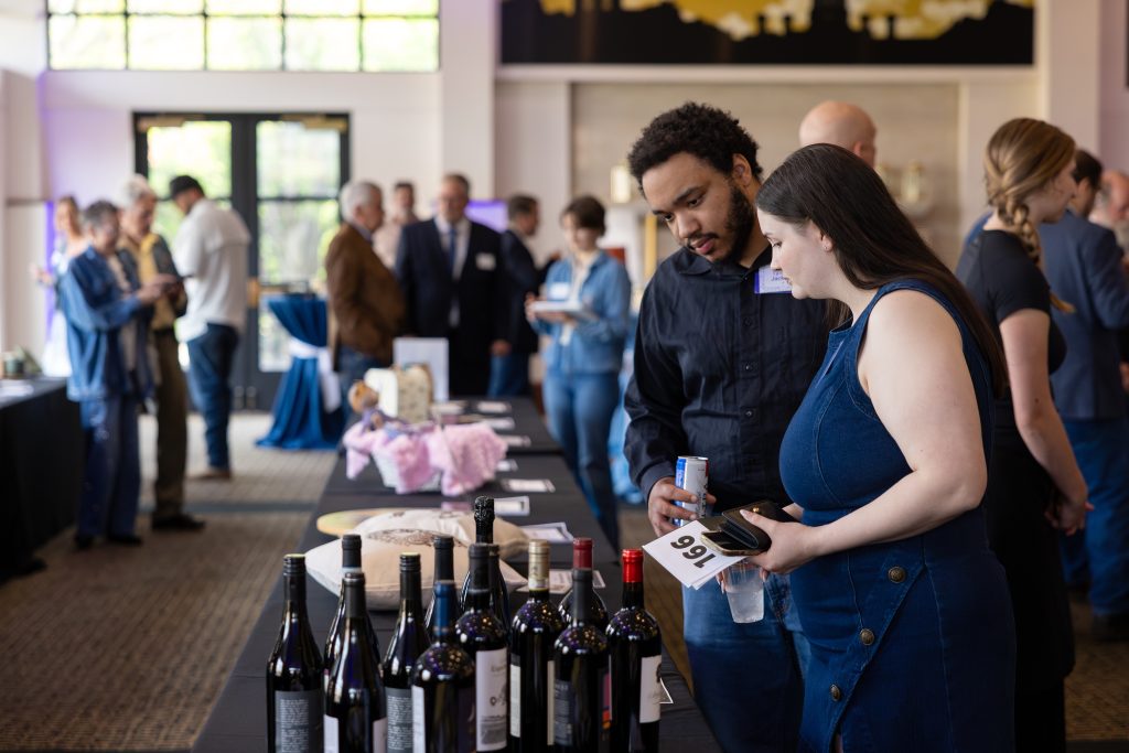 a man and woman peruse the wine selection