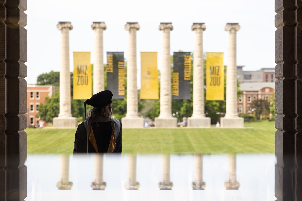 a woman stands in ragalia with the columns in the background