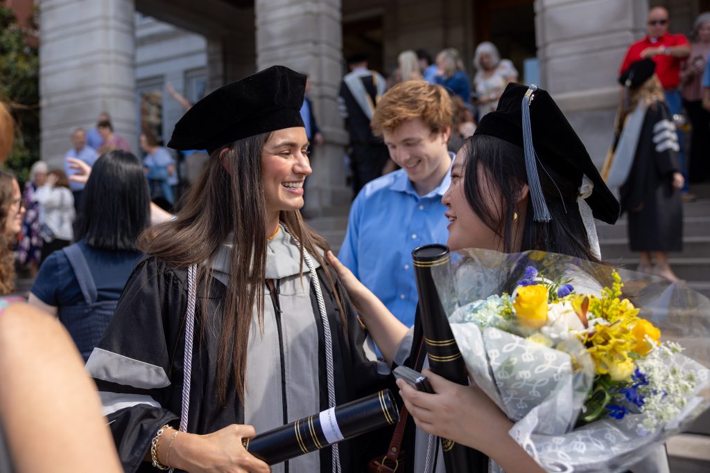 students celebrate in regalia outside jesse hall