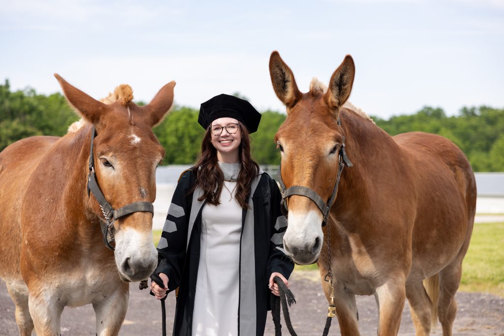a graduate in regalia with mules boone and george