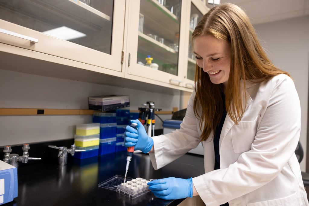 Jessi Miller in the lab smiling while working