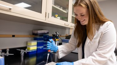 Jessi Miller in the lab smiling while working