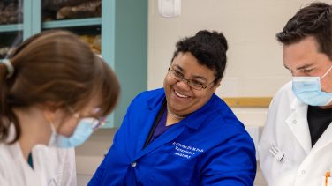 Rowena Woode smiling at a student.